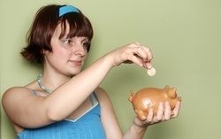 Woman putting money in a piggy bank