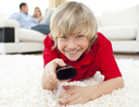 Boy holding a remote control watching TV