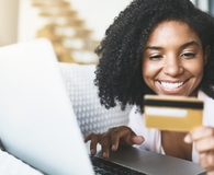 Woman using debit card to shop online