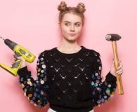 Young adult woman holding working tools in hands