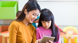 Teacher teach girl student with tablet computer